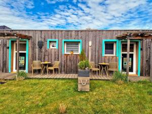 a wooden deck with a table and chairs on it at Coastline Apartments in Fuhlendorf