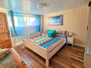 a bedroom with a bed with a colorful comforter at Coastline Apartments in Fuhlendorf