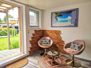 two pink chairs in a room with a window at Coastline Apartments in Fuhlendorf