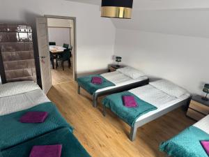 a room with three beds and a table and a mirror at Krause Park in Łęknica