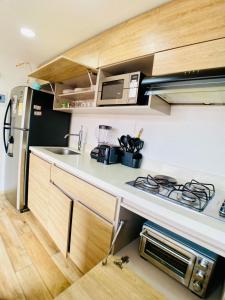 a small kitchen with a stove and a microwave at Beautiful Apto in Poblado in Medellín