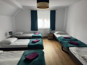 a room with three beds with green blankets at Krause Park in Łęknica