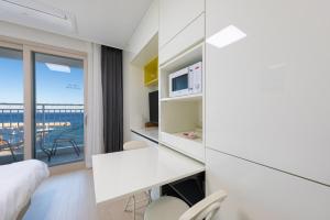 a hotel room with a desk and a view of the ocean at Yangyang Badastay in Yangyang +10 photos