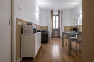 a living room with a kitchen and a table with a microwave at Leoncino Apartment in Verona