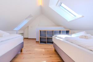 a attic bedroom with two beds and a window at Ferienwohnung Stöfs in Behrensdorf