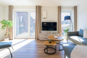 a living room with a couch and a tv at Strandläufer 1 4 - Kellenhusen in Kellenhusen