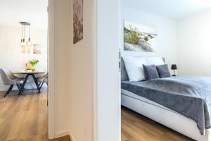 a bedroom with a bed and a dining room with a table at Strandläufer 1 4 - Kellenhusen in Kellenhusen