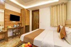 a hotel room with a bed and a desk at Hotel Grand Kings Premium in New Delhi