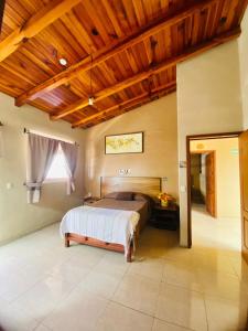 a bedroom with a bed and a wooden ceiling at Hotel el Leñador in Mazamitla