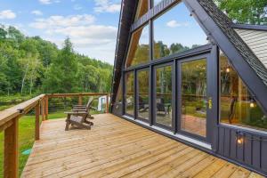 a wooden deck with a bench on a house at Chalet au Bord de l'Ecluse in Brébeuf