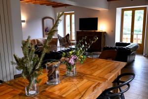 a living room with a wooden table with flowers on it at Gîte à l'origine in Montgesoye +8 photos