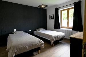 a bedroom with two beds and a window at Gîte à l'origine in Montgesoye