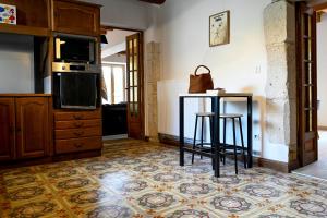 a kitchen with a counter and a table in a room at Gîte à l'origine in Montgesoye