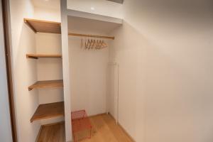 a walk in closet in a room with wooden shelves at Brume Surf House in Messanges