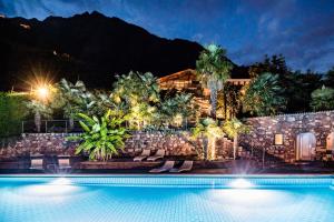 a resort with a swimming pool at night at Nutzhof - Mediterran Flair Hotel in Lagundo