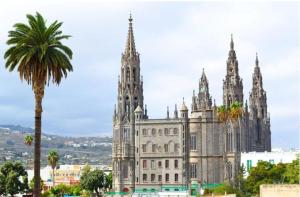 a large building with a palm tree in front of it at Nido De Mar in Santidad