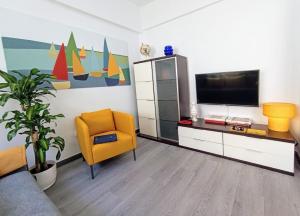 a living room with a tv and a yellow chair at Nido De Mar in Santidad