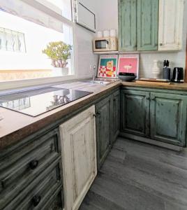 a kitchen with green cabinets and a sink at Nido De Mar in Santidad +28 photos