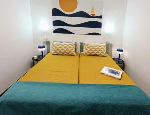 a bedroom with a bed with a yellow and blue blanket at Nido De Mar in Santidad