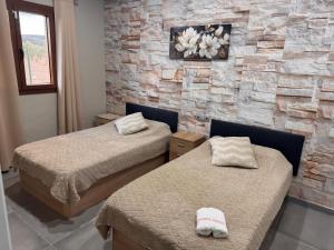 two beds in a room with a stone wall at Complejo Rural Santa Emma in Herencia +12 photos