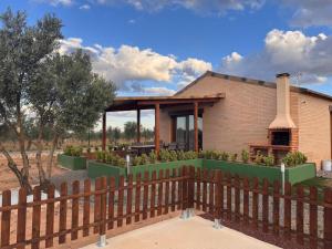 a house with a fence in front of it at Complejo Rural Santa Emma in Herencia