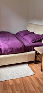 a bed with purple sheets on it in a room at Kuća za pravi odmor in Kolašin