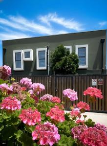 a house with pink flowers in front of a fence at Hostal Madrid in Talca