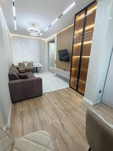 a living room with a couch and a table at Современные 2-комнатные апартаменты в ЖК Capital City рядом с Shym City Park in Shymkent