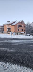 a building on the side of a road with snow at hotel il ghiro in Ovindoli