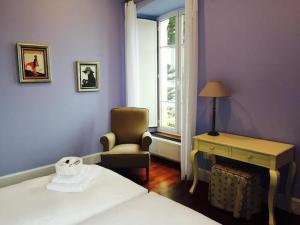 a bedroom with a bed and a chair and a desk at Hotel La Balastrera in Ribadeo