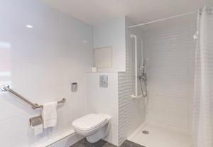 a white bathroom with a toilet and a shower at B&B HOTEL Brumath Bernolsheim in Brumath +31 photos
