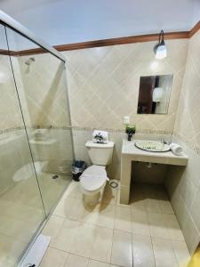 a bathroom with a shower and a toilet and a sink at Hotel el Leñador in Mazamitla +45 photos