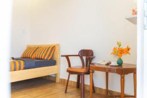 a bedroom with a bed and a table with a chair at Villa Tuan Vu Da Lat in Da Lat