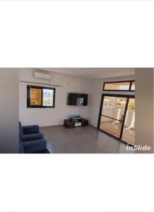 a living room with a couch and a glass door at la perle de ngaparou in Saly Portudal