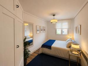 a small bedroom with a bed and a mirror at Hauda in Sopelana