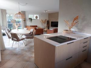 a kitchen with a table and a dining room at Duinvilla Wetterwille met sauna in Makkum