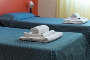 two blue beds with towels on top of them at VMHostel in Montecatini Terme