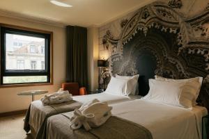 a hotel room with two beds with a large headboard at Hotel Marques De Pombal in Lisbon +81 photos