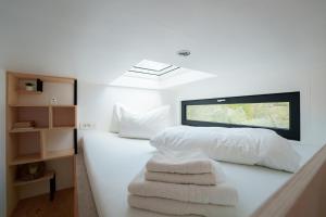 a bedroom with a bed with white sheets and towels at Coniferis in Tomnatic