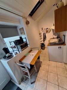 a small kitchen with a wooden table in a room at Studio 11, Draps, Linge, Wifi # Longère Bretonne#Morbihan in Sulniac