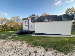 a car parked in front of a white garage at Kovač Home in Posušje