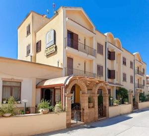 a large building with an archway in front of it at Sammartano Hotels in Marsala