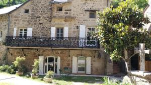 an old stone house with a balcony at La chambre d'hôtes du moulin de Vignars in Ginals
