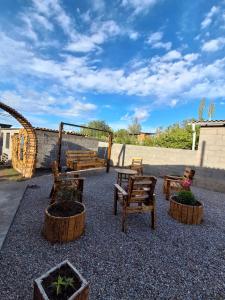 a patio with wooden chairs and potted plants at Keremet Yurt in Bokonbayevo