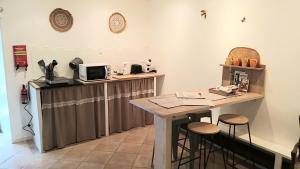 a kitchen with a counter with a table and stools at La chambre d'hôtes du moulin de Vignars in Ginals