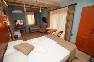 a bedroom with a large white bed in a room at Lotus Konaklama Küçükköy in Ayvalık