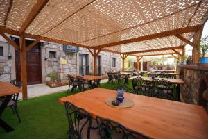 an outdoor patio with wooden tables and chairs at Lotus Konaklama Küçükköy in Ayvalık