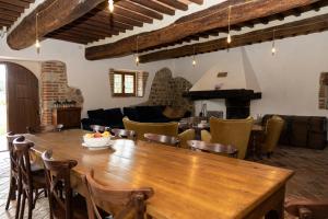 a living room with a wooden table and chairs at Mulino di Pari - Where Time Slows in Pari
