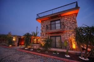 a building with lights on the side of it at Lotus Konaklama Küçükköy in Ayvalık +52 photos