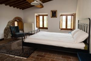 a bedroom with a large bed and a chair at Mulino di Pari - Where Time Slows in Pari +18 photos